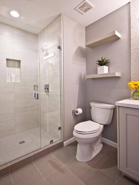 Floating shelves adorn this contemporary bathroom. A free standing shower is covered in tile and boasts the neutral color palette that flows throughout the space. Modern Contemporary Bathrooms, Snowman Stocking, Standing Shower, Simple Bathroom Decor, Storage Inspiration, Floating Shelves Bathroom, Stocking Hanger, Girls Bathroom, Contemporary Bathrooms