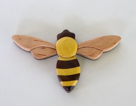 "IN STOCK - FREE DOMESTIC SHIPPING Our mini honey bee is made from 12 segments of yellowheart, maple, & black walnut. Available as a magnet or ornament. Free personalized engravings are available for ornaments. Grain and color will vary some. Dimensions are approximately 3\" by 2\" and weighs 1-2 oz. If you wish to purchase more than the available quantity, please message us as we may have additional in-stock. Intarsia is a mosaic art form that uses small segments of wood to make an image. W Whirligigs Patterns, Rustic Wood Projects, Intarsia Wood Patterns, Wood Bees, Bee Painting, Wooden Magnets, Wood Animal, Wooden Christmas Ornaments, Bird Decor