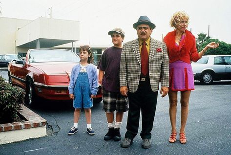 Matilda (1996). L to R: The older Matilda Wormwood (Mara Wilson), the older Michael Wormwood (Brian Levinson), Harry Wormwood (Danny DeVito), & Zinnia Wormwood (Rhea Perlman). This is a still photograph from the movie. Zinnia: “It’s nice to go out sometimes, isn’t it?” Harry: “Yeah.” Zinnia: “You never take us out.” Harry: “Of course I do. I took you to The Flipper.” Zinnia: “I don’t remember any of The Flipper.” This movie is based on the children's novel Matilda (1988) by Roald Dahl. Mrs Wormwood, Matilda Cast, Matilda 1996, Matilda Costumes, Movies From The 90s, Matilda Movie, Matilda Wormwood, Film Quiz, Mara Wilson