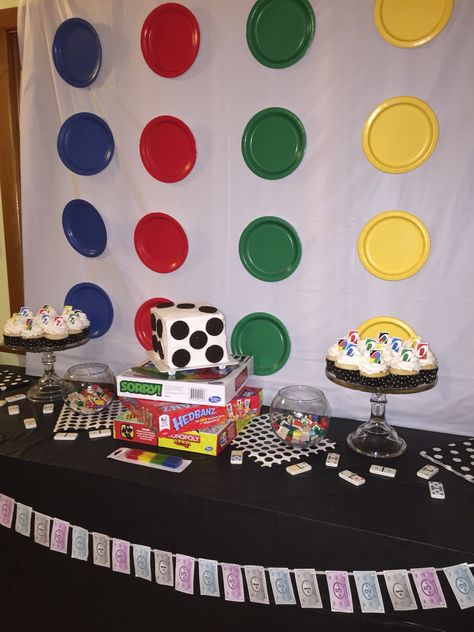 Game night party twister board tablecloth and paper plates, scattered game piece confetti, Monopoly money banner Game Night Photo Booth, Family Game Night Decorations, Game Night Set Up, Board Game Birthday Party Ideas, Board Game Theme Party Decorations, Game Night Party Decorations, Board Game Night Party, Game Night Party Ideas, Money Banner