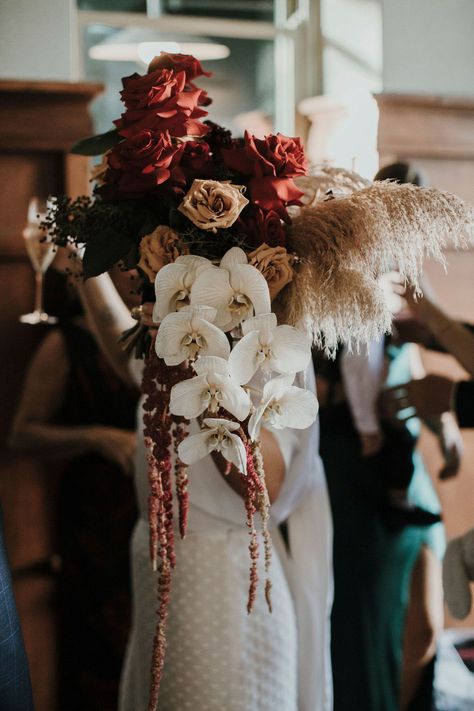 This gorgeous dark and moody wedding in Australia is bursting with crimson red roses and lots of laughter. Set in a the historical Guildhall event space this wedding is the party of the century! Dark And Moody Wedding Florals, Punk Wedding Bouquet, Moody Romantic Bridal Bouquet, Moody Dahlia Bouquet, Gatsby Aesthetic, Moody Cascade Bouquet, Wedding Installation, Florist Inspiration, Moody Red Florals