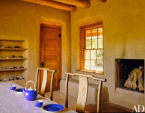 Georgia O'Keeffe's Ghost Ranch in New Mexico. I love the neutral monotone colour scheme, with the pop of blue crockery. It's genius. Also love the wood fireplace in the kitchen (imagine that early on a cold morning? How cosy). Also love the exposed beams. Georgia Okeeffe, Ghost Ranch, Plywood Table, Georgia Okeefe, House Design Ideas, Flagstone Flooring, Pump House, Mexico Style, Adobe House