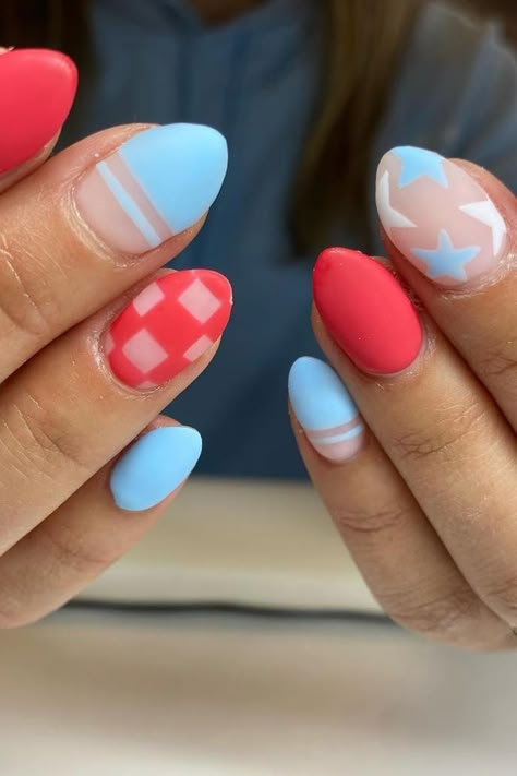 These almond-shaped nails present a sweet pastel palette, perfect for spring. The designs include a soft blue with minimalist white stripes, a playful pink gingham pattern, and a vibrant coral. Additionally, there's a nail featuring white stars on a powdery blue background and another with a chic, transparent base accented with white lines. This mix of patterns and solids is refreshingly charming and full of personality. 🌸✨  // Photo Credit: Instagram @nailsby.syd Baby Blue 4th Of July Nails, Matte 4th Of July Nails, Fourth Of July Nails Checkered, Forth Of July Nails Almond Shape, Muted 4th Of July Nails, 4th Of July Nails Pastel, Subtle Red White And Blue Nails, 4th Of July Aura Nails, Light Blue 4th Of July Nails