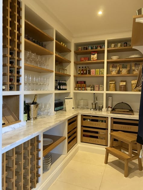 One of our favourite and most admired rooms in the Skipton showroom. It demonstrates what you can make of a small space with clever design. The pantry features a combination of open shelving in oak and painted cabinets in #WimborneWhite by Farrow & Ball. The worktop in Athena Marble, gives a luxurious feel and cool practicality for food storage. The pantry storage is multi-functional, from food and drink, to crockery and glassware, it's a real luxury to have this space near your kitchen. #pantry Clever Storage Ideas For Small Spaces Kitchen, Pantry And Wine Storage, Pantry Wine Storage Ideas, Butlers Pantry Wine Storage, Luxury Food Storage Room, Open Storage Pantry, Wine Storage Pantry, Food Storage Design, Open Shelving In Pantry