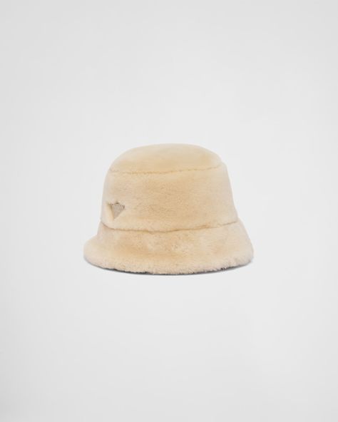 The bucket hat, an iconic accessory that distinguishes Prada collections, is made of shearling and decorated with the enameled metal triangle logo. Prada Gifts, Prada Runway, Porcelain Candle, Barbie Dolls Diy, Prada Collection, Glamorous Dresses, Tableware Collection, Triangle Logo, Women Essentials