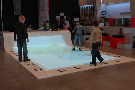 The Story Surfer, Aarhus Library, Denmark. At Aarhus, even the floor is interactive.  The StorySurfer is a huge touch sensitive floor that allows kids to search the Aarhus catalogue, literally by walking around inside of it. Interactive Library, Multimedia Technology, Teen Library, Future Library, Interactive Multimedia, Library Inspiration, Public Libraries, Childrens Library, Human Centered Design