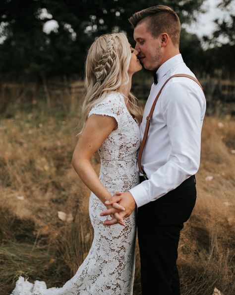 Romantic barn wedding, braid hair, baby’s breath, groom, black pants, brown suspenders, elegant, field, grass, blonde hair Black Pants Brown Suspenders Groomsmen, Blonde Groom Suit, Barn Wedding Groom Attire, Groom With Suspenders, Brown Suspenders Groomsmen, Brown Suspenders Wedding, Black Pants Brown Shoes, Wedding Garments, Wedding Barn Ideas