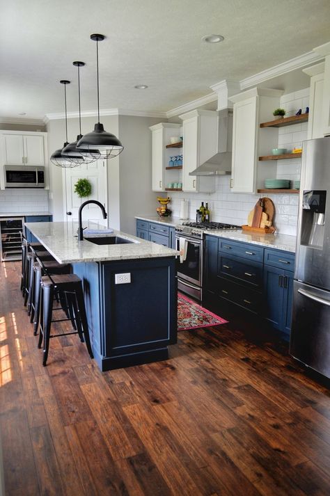 gorgeous kitchen remodel with dark wooden flooring, deep sea blue cabinets, open shelving, unique lighting fixtures Two Tone Kitchen Cabinets White And Blue, White Subway Backsplash, Dark Blue Kitchen Cabinets, Dark Kitchen Floors, Two Toned Kitchen Cabinets, Dark Blue Kitchens, Spanish Style Kitchen, Dark Wooden Floor, Subway Backsplash