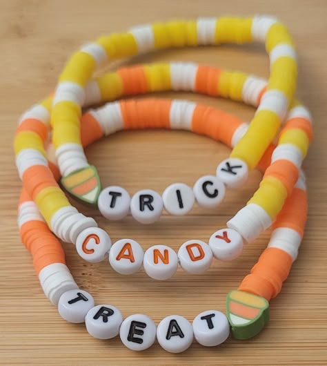 Sweeten up your Halloween with these adorable candy corn-themed stretch bracelets! Featuring vibrant yellow, orange, and white beads, along with playful "TRICK," "CANDY," and "TREAT" letter beads, this set is perfect for adding a festive touch to your Halloween outfit. Features: Set of 3 Bracelets: This set includes three fun and colorful stretch bracelets, each with a candy corn-inspired design. One set features polymer clay heishi beads, while the other uses round silicone beads accented with Bracket Inspo Beads, Clay Bead Halloween Bracelet Ideas, Bracelets To Make And Sell, Candy Corn Bracelets, Clay Beads Halloween, Halloween Bracelet Ideas Clay, Pony Beads Bracelet Ideas, Halloween Clay Bead Bracelet Ideas, Halloween Clay Bead Bracelet