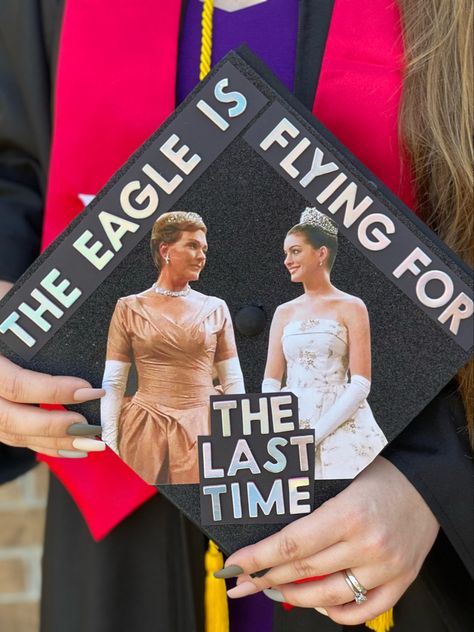 The picture is of a graduation cap that says “the eagle is flying for the last time” which is a quote from the movie. It has colored pictures of the queen and princess of Ginovia from the movie, The Princess Diaries. She Doesn’t Even Go Here Graduation Cap, Cars Movie Graduation Cap, Princess Diaries Grad Cap, Grad Cap Ideas College First Generation, Graduation Cap Designs Disney Princess, College Grad Caps Ideas, 10 Things I Hate About You Grad Cap, New Girl Graduation Cap, High School Musical Grad Cap