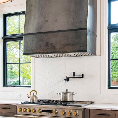 #Sundays in the #Kitchen New build details... Custom designed carbonized steel #RangeHood and #Chevron #Mosaic #backSplash! Gorgeous! Seldom does a range hood become the centerpiece, but in this kitchen, it’s all everyone is talking about. 🔥🔪👩‍🍳 #NewBuild #NashvilleInteriorDesigner #Architecture #InteriorDesign #KitchenBuild #kithcenNewBuild #HomeDesign #HomeRenovation #HomeDecor #Stove #ZigZagBackSplash #customHood #InstaHome #KithechenIsTheHeartofaHome #ovenHood #CustomKitchent Tall Range Hoods, Black Viking Range In Kitchen, Steel Range Hood Ideas, Range Hood Steel, Concrete Look Range Hood, Cement Range Hood, Metal Hood Vents Kitchen, Black Plaster Range Hood, Modern Oven Hood Ideas