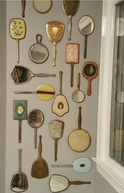 Wall Of Mirrors Bathroom, Vintage Hand Mirror Display, Vintage Trinkets Aesthetic, Wall Trinkets, Hand Mirror Wall, Old Hollywood Interior Design, Vintage Mirror Wall Decor, Dark Academia Room Ideas, Mirror Gallery