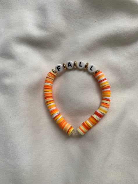 A fall themed bracelet. Cool Bead Bracelet Patterns, Braclet Ideas Clay Bead Fall, Thanks Giving Bracelets, Preppy Fall Bracelet Ideas, Preppy Halloween Bracelet, Clay Bead Bracelet Ideas Thanksgiving, Fall Bracelets String, Halloween Diy Bracelets, Fall Themed Bracelets