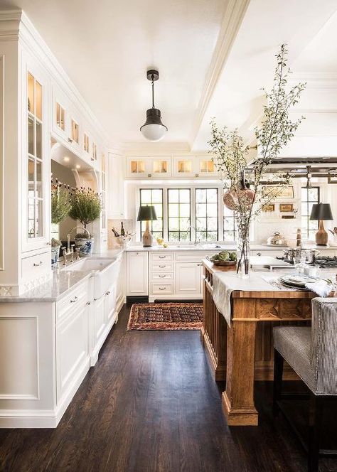 This expansive white and brown kitchen, lit by a Kelly Wearstler Precision Pendant, boasts a large brown wooden island seating black and white stripe counter stools at a wood countertop. French Country Style Kitchen, French Country Kitchen Designs, Rustic Farmhouse Kitchen Cabinets, French Country Decorating Kitchen, Country Kitchen Designs, Farmhouse Kitchen Cabinets, Farmhouse Kitchen Design, Rustic Farmhouse Kitchen, Bedroom Decorating Ideas