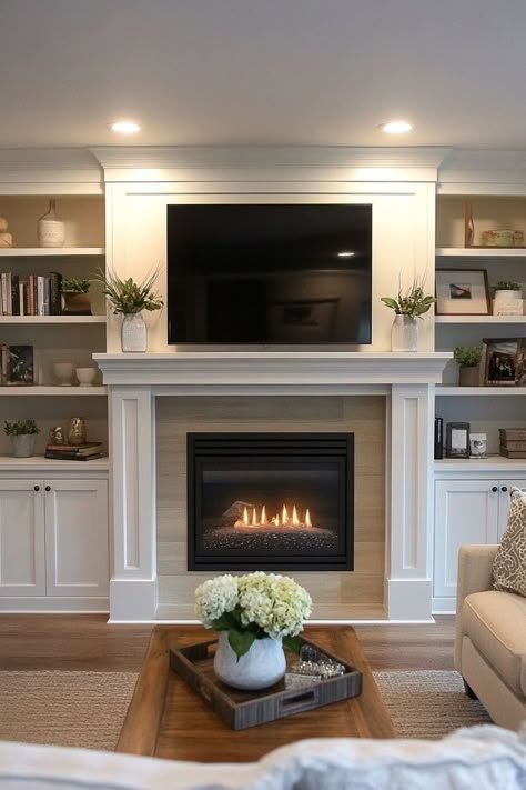 Reimagine your living room with stylish fireplace built-ins that feature a TV, painted shelves, and a modern design. These ideas center around a built-in fireplace wall, enhanced by elegant bookshelves that provide ample storage and display options. Create a unit that exudes sophistication and warmth, ensuring your living space is both inviting and contemporary. Shelves On Fireplace Wall, Electric Fireplace And Mantle Ideas, Mounted Living Room Tv Ideas, Entertainment Center Fireplace Ideas, Shelves In Lounge, Decorating Fireplace With Tv Above It, Living Room Wall Built Ins, Fireplace And Bookshelf Wall, Bookshelves With Tv In The Middle