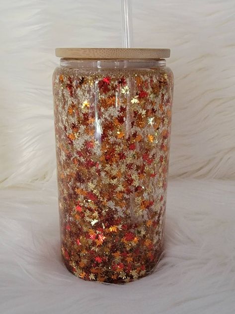 Beautiful maple fall leaves snow globe double wall glass can. Cup is filled with gold, red and orange maple shaped leaves, and fine gold glitter. Cup is 16oz in size, but fits 12oz of liquid. NOTE: I have a variety of colors of glitter, please message me if you would like a different color. You will receive snow globe cup, one clear plastic straw and bamboo lid. If you choose name option, please add name/text, font style and vinyl color.  CARE INSTRUCTIONS: - Not dishwasher safe - Handwash only Snow Globe Cup, Autumn Snow, Fall Maple Leaves, Christmas Cups, New Business Ideas, Leaves Autumn, Double Wall Glass, Custom Tumbler Cups, Glass Coffee Cups