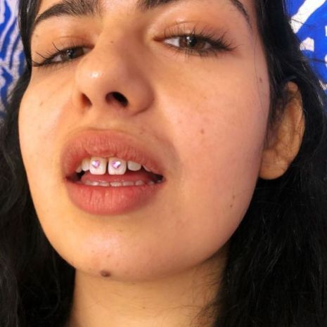 Piercing no dente: item fashionista ou delírio coletivo? Ao que parece, o acessório está de volta com tudo (e eu não posso nem fingir que o adereço dentário foi um surto coletivo, afinal, querida leitora, eu tive um no meu, lá nos anos 2000’s!!!). Se você foi adolescente nos anos 80, 90 ou 2000’s, com certeza foi impactada por essa tendência que brilhava na boca dos jovens daquela época. Não era um piercing de verdade, claro, apenas uma pequena joia ou strass colado no dente. #piercing Stone Makeup, Teeth Art, Gap Teeth, Tooth Gem, Teeth Jewelry, Pretty Smile, Fly Girl, Fashion Line, Fall Fashion Outfits