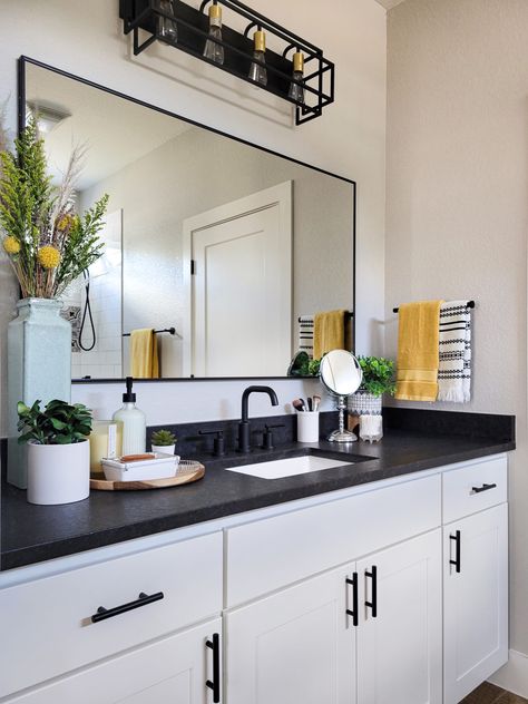 Guest Bathroom Ideas Black Countertop, Black And White Cabinets Bathroom, Boho Bathroom Black Countertop, Black Counter Bathroom Decor, White Vanity Dark Countertop, White And Black Vanity Bathroom, Bathroom Interior Design Dark Countertop, Black Countertop Bathroom Decor, White Bathroom Cabinets With Black Countertops