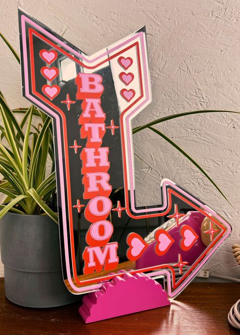 Add a touch of nostalgia and quirkiness to your home with our Retro Bathroom Mirror, available in two sizes. Featuring a neon sign-inspired design with a playful arrow shape in pink and red, it's a fun addition to any room. Comes with COMMAND strips for hanging UV printed vinyl & acrylic mirror Small Size: 24cm x 17cm Large Size: 37cm x 29cm Neon Sign Over Mirror, Cute Home Decor Crafts, Aesthetic Home Decor Ideas Diy, Cute Wallpaper For Bathroom, Tattoo Bathroom Decor, Red Theme Bathroom, Neon Gallery Wall, Retro Theme Bedroom, Neon Signs Bathroom