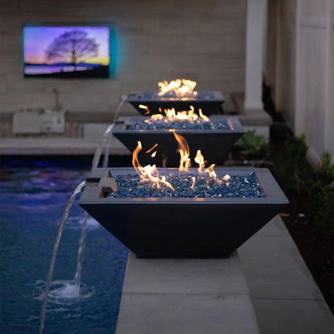 A stunning display of The Outdoor Plus Maya Fire and Water Bowls in slate finish, showcased poolside with cascading water features and a flickering fire atop blue glass rocks. These square concrete fire and water bowls create a serene and luxurious atmosphere, perfect for outdoor living spaces. Ideal for modern patios, backyards, or pool areas, combining fire pit functionality with a sleek water element Gfrc Concrete, Geode Decor, Florida Pool, Fire And Water, Fire Designs, Fire Water, Backyard Pool Designs, Backyard Retreat, Backyard Living