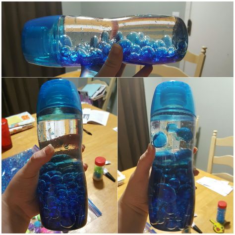 Sensory bottle!!  1. Soak three different sizes/shades or colors of water beads overnight. Mine weren't fully expanded until about 10 hours even though the package said 4-6 hours.  2. Take label off Core or Voss water bottle.  3. Fill a little less than half of the bottle with water beads.  4. Add about half as much water, then add three drops of food coloring to water/beads and shake up.  5. Fill remaining space with baby oil.  6. Make sure to superglue the top on. Core Water Bottle Crafts, Diy Ocean Sensory Bottles, Sensory Bottles With Clear Glue, Oil And Water Sensory Bottle, Glitter Glue Sensory Bottle, Voss Water Bottle, Oil Water Glitter Sensory Bottle, Water Bottle Crafts, Bead Bottle