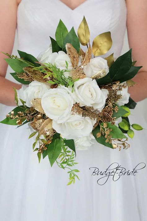 This is a round brides bouquet with a mixture of all white roses accented with gold glitter foliage, gold berries and foliage. All of our wedding bouquets are made with artificial wedding flowers. Prom Flowers Bouquet, Gold Wedding Bouquets, Davids Bridal Gowns, Gold Wedding Flowers, Blush Bouquet Wedding, Green Wedding Bouquet, Gold Bouquet, White Winter Wedding, Winter Wedding Bouquet