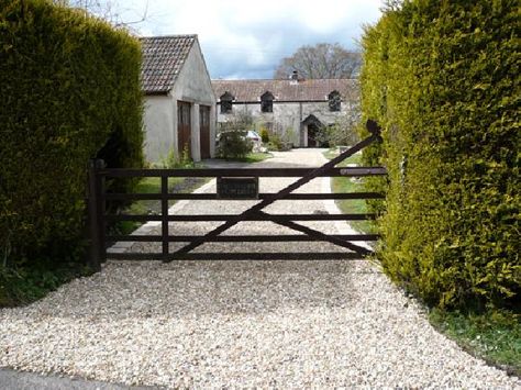 gravel color. gate and hedge. Stable Courtyard, Pea Gravel Driveway, Gravel Driveway Ideas, Farm Exterior, Pea Gravel Garden, Driveway Apron, Gravel Drive, Driveway Entrance Landscaping, Gates Driveway