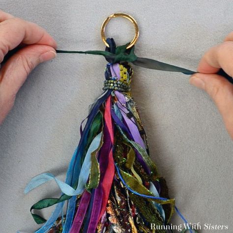 Make a tassel from scraps of ribbon and trims. It's easy! We'll show you how to tie the trims into a decorator tassel to wear or use as a keychain! Make A Tassel, Yarn Ribbon And Thread, Diy Tassel Necklace, Tassels Tutorials, Tassel Crafts, Jewelry Fabric, How To Make Tassels, Diy Tassel, Easy Craft Projects