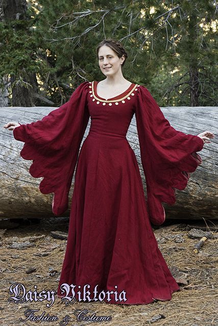 This gown, a tran­si­tional style between a cote­hardie and a houp­pelande, is based on 15th cen­tury Ital­ian sources. The dress is made of red wool and fully lined. The dress laces on the sides with hand sewn eye­lets and hand made fin�­ger loop braid. The neck­line is accented with gold silk and span­gles, a pre­cur­sor to mod­ern sequins. The gown is worn here both with braided hair and with a dec­o­rated hat. Loop Braid, Medieval Garb, Medieval Clothes, Queen Costume, Fantasy Dresses, Medieval Costume, Century Clothing, Medieval Dress, Medieval Clothing