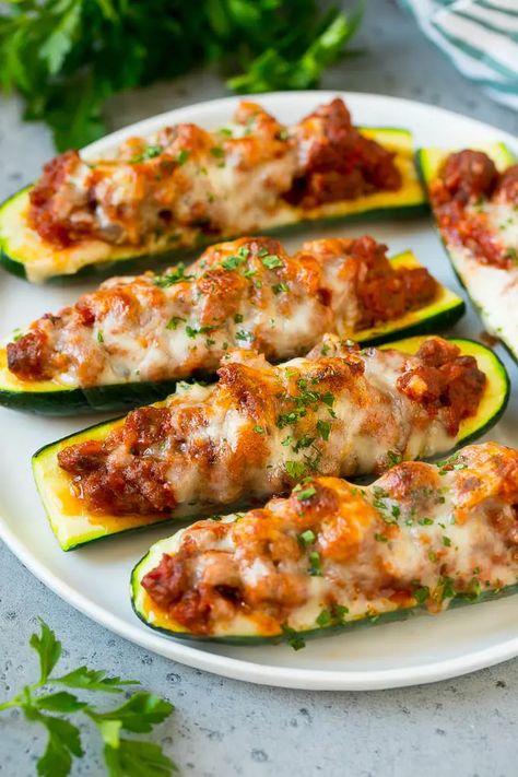 A plate of stuffed zucchini boats filled with a savory meat sauce and topped with mozzarella cheese. Zucchini Stuffed, Zucchini Boat Recipes, Stuffed Zucchini Boats, Sommer Mad, Sausage Stuffed Zucchini, Zucchini Pizzas, Stuffed Zucchini, Diner Recept, Zucchini Boats