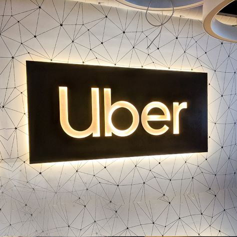 Illuminated black wood lobby sign with warm light on geometrical wallpaper for Uber, an American multinational transportation network company.. Geometrical Wallpaper, Company Logo Wall, Kitchen Paintings, Lobby Sign, Old House Interior, Reception Signage, Office Signage, Office Logo, Merchandising Ideas