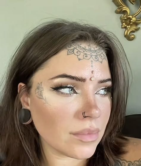 Womens Under Chin Tattoo, Dermal Piercing Forehead, Forehead Tattoo Woman Hairline, Forehead Dermal Piercing, Cheekbone Tattoo, Forehead Dermal, Forehead Tattoo Woman, Tiny Face Tattoos For Women, Forehead Piercing