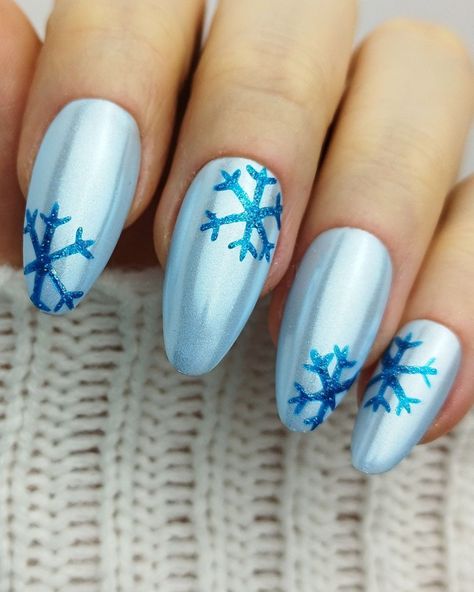 Shine like ice with these blue chrome nails featuring delicate snowflakes! These winter nail designs will give you that frosty look you’ve been searching for. Get inspired by these stunning winter nail ideas and winter nail inspo. Find your next winter nail art on the blog, including these light blue nails with glitter snowflakes for winter. Ice Blue Christmas Nails, Winter Nails Blue Snowflakes, Ice Blue Nail Designs, Blue December Nails, Light Blue Nails With Glitter, Blue Snow Nails, Winter Nails With Snowflakes, Chrome Winter Nails, Ice Blue Nails Winter