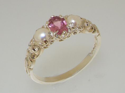 This charming vintage style ring is set with a central 6x4mm natural pink tourmaline with a 4mm freshwater pearl either side. It has a beautiful carved scroll design on the shoulders, which offsets the polished white gold. The ring can be made in 9,10, 14 or 18K gold.  Please note that due to the individual nature of natural gemstones the colour of stones may vary between rings. If you have specific requirements for the stone, please contact our friendly team and we'll do our best to accommodate Cute Engagement Rings, Trilogy Ring, Magical Jewelry, Jewelry Lookbook, Pretty Rings, Girly Jewelry, Jewelry Inspo, Dream Jewelry, Stylish Jewelry