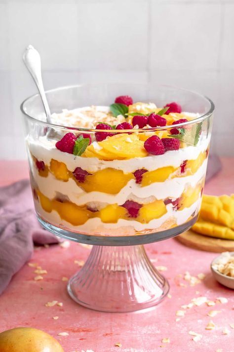 This tropical mango trifle has layers of spongey angel food cake, mango puree and fresh mango chunks, coconut whipped cream, and toasted coconut flakes. It's bright, fruity, and creamy all in one bite. Mango Parfait Desserts, Fruit Trifle Desserts, Mango Trifle Recipes, Mango Trifle, Mango Parfait, Cake Mango, Raspberry Trifle, Fruit Trifle, Coconut Sorbet