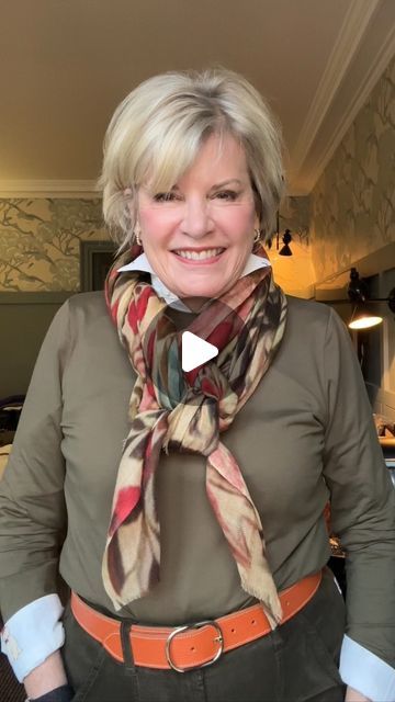 Ann Fulton on Instagram: "Parisian Pretzel Knot  I admit, I can't get enough of scarves in Paris. This is my favorite, but it doesn't seem easy until you break it down. Enjoy  When you’re looking for scarves, look for ones that are many colors and include your hair color. They will go with most of your clothing and will be useful for connecting different colors.  My scarf is from Marc Barrel, my top is AnueMiani, belt from my stash.  #styleover60 #styleover70 #styleover50 #fashionover60 #styleatanyage #agelessstyle #over60 #over50style #over60andfabulous #fashionover50 #scarvesfordays #easyscarfstyle #parisianstreetstyle #parisianscarfskills #traveleardrobe #marcbarellparis" Oblong Scarf Tying Ideas, Square Silk Scarf Tying, Square Scarf How To Wear A, Hermes Scarf Outfit, Scarf Tying Tutorial, Weekend Getaway Outfits, Fashion Installation, Dapper Mens Fashion, Street Style Parisian