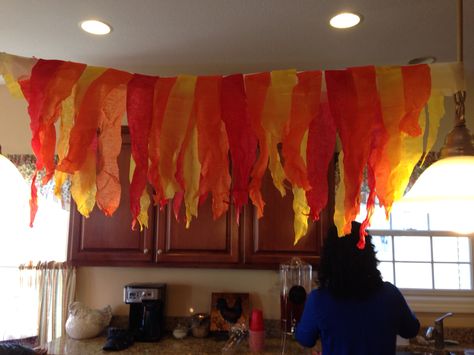 Paper streamer flames Fiery Furnace Decorations, Construction Paper Fire Flames, How To Make Fake Fire With Tissue Paper, Flame Decorations, Fire And Ice Decorations, Tissue Paper Flames Fire, School Hallway Decorations, Crepe Paper Decorations, Game Of Thrones Birthday