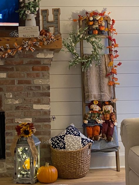 The blanket ladder has fall additions of scarecrows sitting on the ladder as well as a Garland of leaves hanging from the top. I added a couple of pumpkins to this side of the mantle as well as hanging my DIY fabric strip Garland. How To Decorate Blanket Ladder, Halloween Blanket Ladder, Blanket Ladder Halloween Decor, Fall Decor With Ladders, Decorating A Ladder For Fall, Fall Decor Ladder, Autumn Ladder Decor, Ladders Decorated For Fall, Ladder Fall Decor