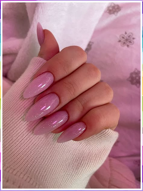 Discover the best almond-shaped winter nail colors and designs Pink Shimmer Acrylic Nails, Pink Nails Almond Shape Glitter, Trending Acrylic Nails Almond Shape, Pretty Nails Almond Shape, Trendy Minimalist Nails Almond, Pink Sparkly Almond Nails, Pink Long Almond Nails, Glittery Almond Nails, Pink Glitter Almond Nails