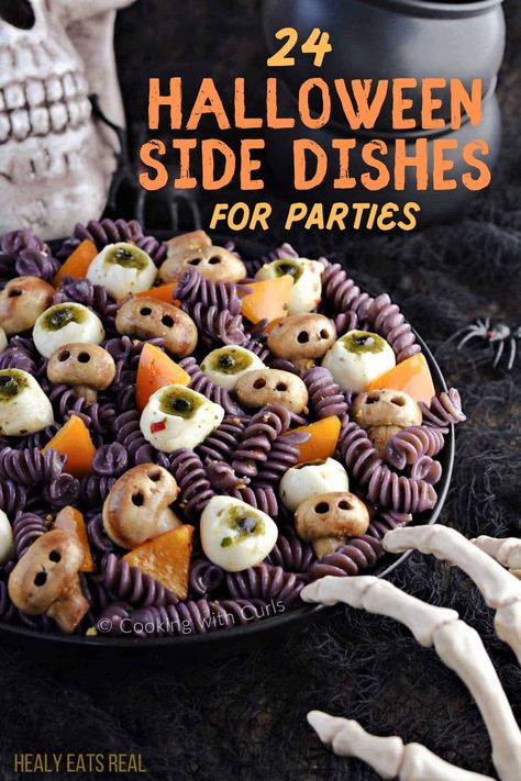 A plate of Halloween-themed pasta containing rotini, mozzarella balls with pesto, and orange bell pepper pieces, garnished to look like skulls; background features a skull and skeleton hand. Text reads "24 Spooky Halloween Side Dishes for Parties." Spider Bread Bowls For Halloween, Easy Halloween Main Dishes, Halloween Cookout Food, Halloween Party Sliders, Halloween Food Ideas Veggies, Halloween Party Menu Food, Ghost Dinner Ideas, Spooky Sides For Halloween, Spooky Halloween Side Dishes