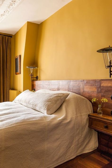 Picture Of a rustic bedroom with warm yellow walls, a wooden bed and nightstands and heavy mustard curtains Yellow Apartment, Yellow Restaurant, Mustard Bedroom, Yellow Bedroom Walls, Forest Hotel, Yellow Bedroom Decor, Yellow Room, Bedroom Wall Paint, Yellow Bedroom