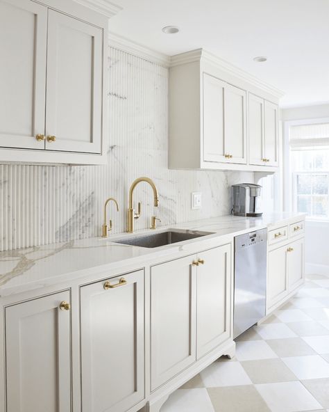 This kitchen transformation features a fluted marble backsplash adding a modern touch. Complete with redesigned sinks, cabinets, and island, the project embodies functionality and style. 📅 2023 📍 Westport 🎨 @claudiaallegrainteriors 🔨 Full renovation. #ODGxMelwoodLane #LivingMadeBetter #InteriorDesign White Marble And Brass Kitchen, White Fluted Kitchen Cabinets, Fluted Backsplash Kitchen, Fluted Kitchen Backsplash, Reeded Glass Kitchen Upper Cabinets, Fluted Backsplash, White Fridge With Gold Handles, Fluted Panel Island Counter, Chic Farmhouse Kitchen