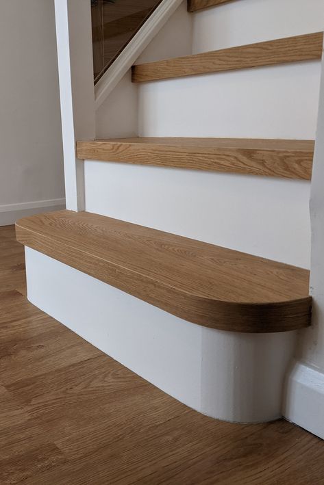 We designed a bespoke contemporary solution cladding each step in engineered oak. We opted for painted risers rather than a full wooden clad, to avoid a sea of wood effect. Real wood gives strength to the staircase and, unlike vinyl, in time it doesn’t wear off on the edges. For the stairs the customers were happy to invest in engineered oak with a modern design solution of white painted risers to match the rest of the property. Painted Wooden Staircase, Wooden Tiles Stairs, Painted Risers On Stairs, Oak Stairs With White Risers, Staircase Oak And White, Wood Effect Tile Stair Treads, White Risers Stairs Dark Wood, Stairs Cladding, Wooden Staircase Design