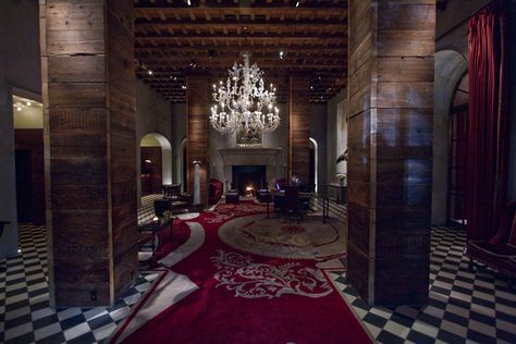 The Lobby at the Gramercy Hotel, New York has black and white checkered floors, red carpeting, wooden columns, exposed ceiling structure, large stone fireplace, arched openings, red drapes, and hanging chandelier. Lobby Architecture, Las Vegas Deals, Gramercy Park Hotel, Hotel Lobbies, Hotel Owner, Entrance Lobby, Gramercy Park, Luxurious Rooms, Romantic Hotel