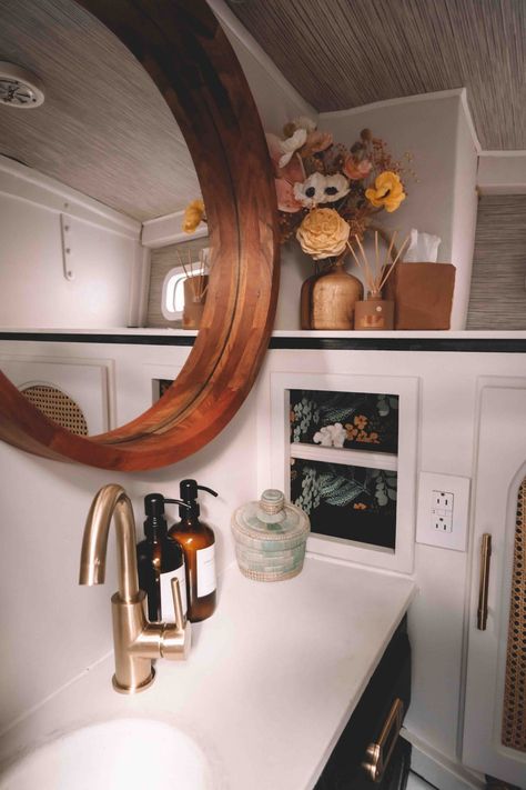 Bathroom with black cabinets and brass hardware, mahogany mirror and flowers Yacht Style Interior Home, Boat Bathroom Remodel, Sailboat Renovation Interior Design, Boat Renovation Interior Design, Sailboat Interior Remodel, Boat Bathroom Ideas, Boat Interior Remodel, Yacht Renovation, Sailboat Makeover