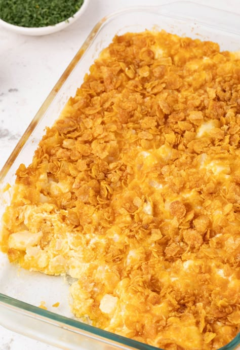 A pan of cooked funeral potatoes Potatoes With Corn Flakes On Top, Cheesy Potatoes Corn Flakes, Cheesy Cubed Potatoes, Homemade Cheesy Potatoes, Cheesy Potatoes With Hashbrowns, Cheese Potato Casserole, Potato Casseroles, Easy Scalloped Potatoes Recipe, Buttery Corn