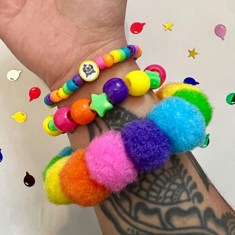 Rainbow Pom Pom clown kandi beaded bracelet set clowncore accessories jewelry  Handmade bracelet set of 3 with chunky rainbow Pom poms and fimo clay clown charm  Perfect accessory to add fun and color to your wardrobe!  *CLOWN BEAD MAY CHANGE TO HAPPY FACE BEADS DEPENDING ON AVAILABILITY! Tags; clown clowncheck clown aesthetic rave Y2K kidcore kandi cuff kandicore kandikid weirdcore whimsical jewelry rainbow bright fun jewelry Clown Kandi, Rainbowcore Fashion, Kidcore Accessories, Kidcore Jewelry, Kid Core Outfits, Glittery Jewelry, Harajuku Decora, Rainbow Pom Pom, Rave Y2k