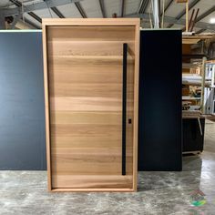 Entry pivot door pictured raw, manufactured from Western Red Cedar and sanded perfectly flat. 2370mm x 1260mm unit with with horizontal 190mm boards. 1800mm long black handle with a roller mortise lock. #pivotdoor #frontdoor #timberdoor #customjoinery Front Door With Long Handle, Modern Cedar Front Door, Pivot Doors Entry Modern Wood, Cedar Front Door, Pivot Doors Entry, Modern Wood Doors, Timber Front Door, Cedar Door, Small House Exteriors