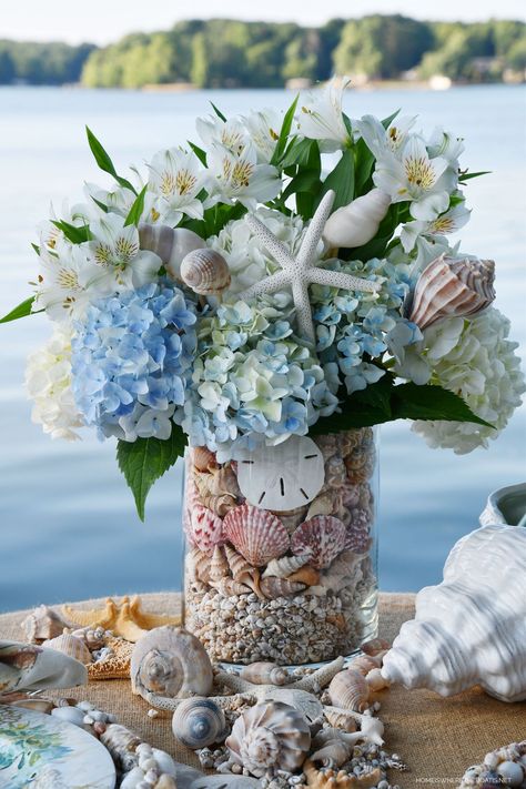 DIY Floral Arrangement with Shells for Seaside-inspired tablescape #lake #diy #flowerarrangement #seashells #beach #tablescape #tablesetting #summer ©homeiswheretheboatis.net Seashells In Glass Containers, Coastal Flower Arrangements, Coastal Floral Arrangements, Beach Flower Arrangements, Flowers For Beach Wedding, 222 Design, Nautical Flowers, Coastal Centerpiece Ideas, Beach Wedding Centerpieces Flowers