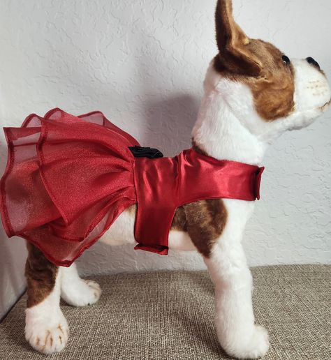 Introducing our Elegant Dog Dress, the perfect attire for pet parties and special occasions! This exquisite dress is made with the finest satin and organza materials, creating a stunning combination of red with black flower detail. Your beloved pet will surely feel like the star of the Christmas season with this elegant outfit.  Highlights: - Made with the finest satin and organza materials - Striking red dress with black flower detail - Perfect for pet parties and special occasions - Conforms to your pet's body for a comfortable fit Benefits: 1. Stand out in Style: Dress your pet in this elegant outfit to make them the center of attention at any event. The striking red dress combined with the black flower detail creates a visually stunning and fashionable look. 2. Superior Comfort: The sm Christmas Dog Dress, Dog Dress Pattern, Elegant Dog, Christmas Dress Up, Christmas Attire, Party Animals, Saree Blouse Designs Latest, Dog Dress, Dog Party